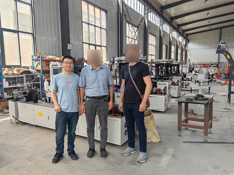 Cliente turco inspeccionando máquina de clavos en bobina